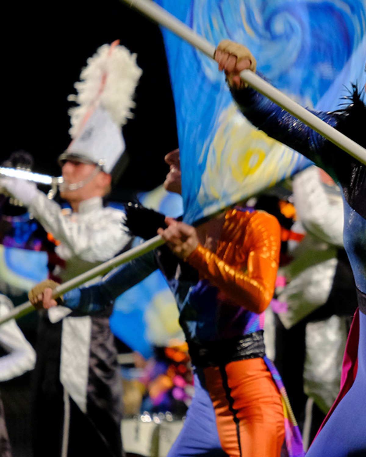 Een color guard-lid van Jubal met een geschilderde ‘Starry Night’-vlag tijdens de show Vincent