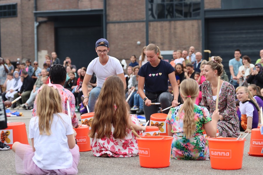 Drie kinderen spelen samen op trompetten bij Music Kids